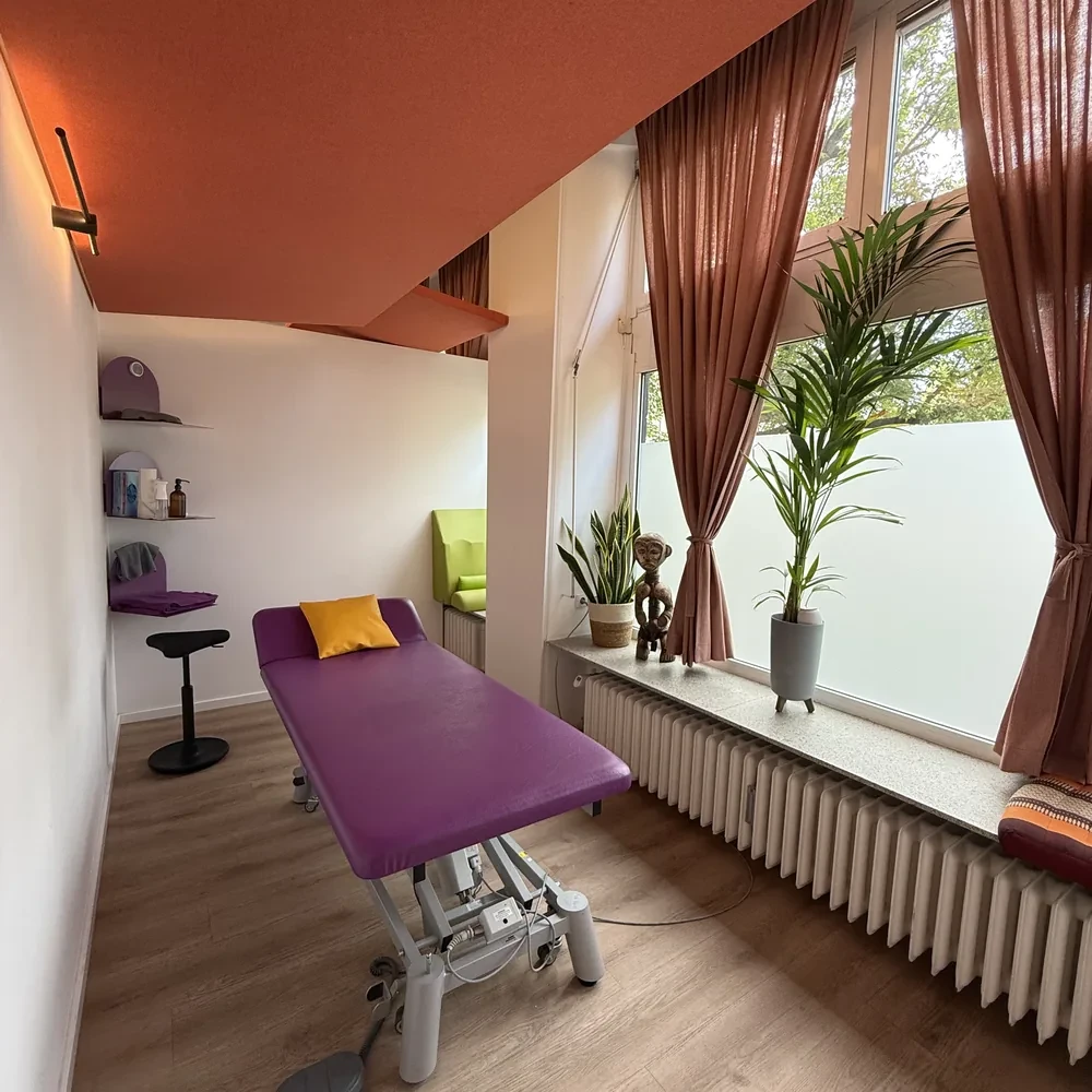 Therapieraum von Fit durch Physio mit lila Therapieliege, Terrakottatönen und Zimmerpflanzen